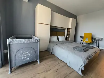 a bedroom with a bed and a yellow chair at DomBox Sofia Suites - Stylish 2 Bedroom in Center - Free Garage in Sofia