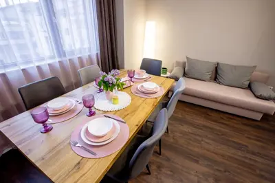 a dining room table with chairs and a couch at Saphi Apt in Sandanski