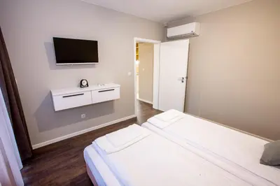 a room with two beds and a tv on the wall at Saphi Apt in Sandanski