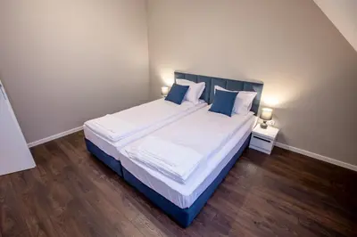 a bedroom with a large bed with white sheets and blue pillows at Saphi Apt in Sandanski