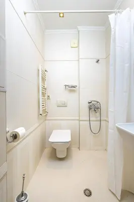 a white bathroom with a toilet and a shower at 1BR Apartment in the Center with Free Street Parking and Designated Workspace in Plovdiv