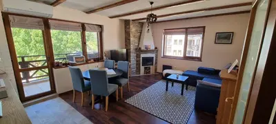 a living room with a table and chairs and a dining room at Lovely 1-bedroom Apartment with Mountain View in Bansko
