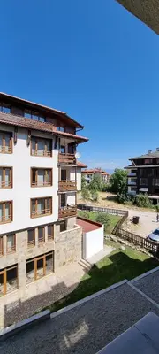 an apartment building with a view of a yard at Lovely 1-bedroom Apartment with Mountain View in Bansko
