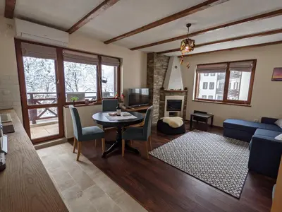 a living room with a table and a couch at Lovely 1-bedroom Apartment with Mountain View in Bansko