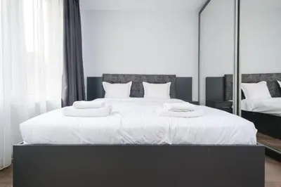 a bedroom with a large white bed with mirrors at Quiet & Comfy 1BR in the Heart of Plovdiv with Private Balcony in Plovdiv