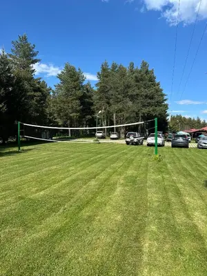 a large grassy field with a volleyball net at Парк-хотел Родопи in Churen