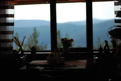 a table in front of a window with a view of mountains at Парк-хотел Родопи in Churen
