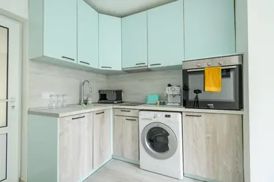 a kitchen with a washing machine and a microwave at Top Center - 2 min from NDK in Sofia