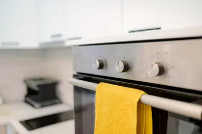 a yellow towel is hanging on the front of an oven at Top Center - 2 min from NDK in Sofia