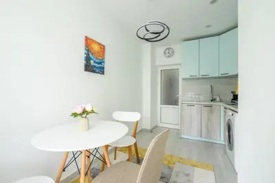 a white kitchen with a white table and chairs at Top Center - 2 min from NDK in Sofia