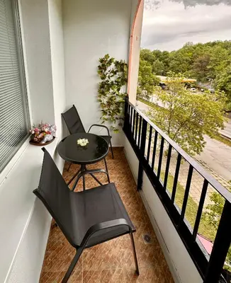 a balcony with a table and chairs and a window at Cozy Home 2 Bedroom apartment in Kyustendil