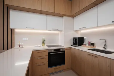 a kitchen with white counters and wooden cabinets at Brand New Luxury Apartments with Great Views in Sofia