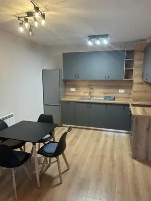 a kitchen with a table and chairs in a room at Cozy and comfortable panorama park Entrance E not K in Plovdiv