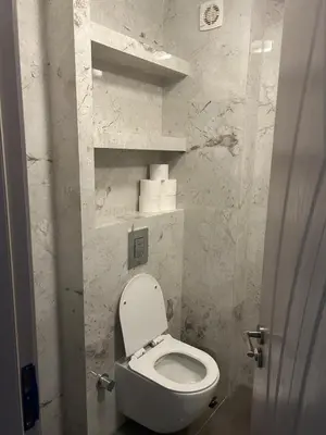 a bathroom with a white toilet in a room at Cozy and comfortable panorama park Entrance E not K in Plovdiv