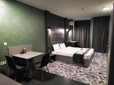 a bedroom with a bed and a table and chairs at RCR Einstein studios 3 in Sofia