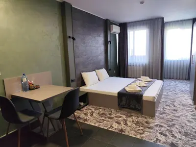a room with a bed and a table and chairs at RCR Einstein studios 3 in Sofia