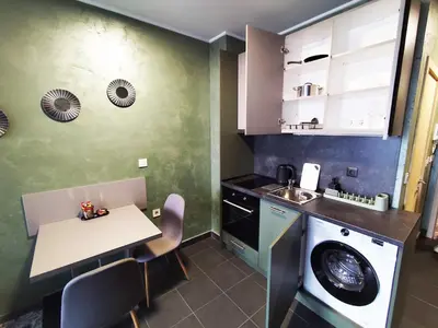 a kitchen with a table and a washing machine at RCR Einstein studios 3 in Sofia