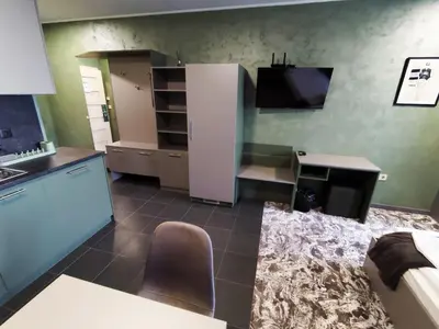 a kitchen with a refrigerator and a table and a chair at RCR Einstein studios 3 in Sofia