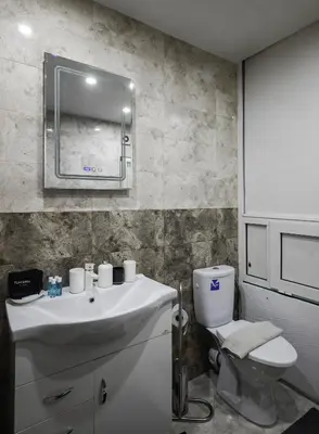 a bathroom with a white sink and a toilet at The Cosmopolitan Shine 1-BDR Pet-Friendly Flat in Sofia