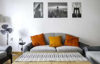 a living room with a gray couch with orange pillows at The Cosmopolitan Shine 1-BDR Pet-Friendly Flat in Sofia