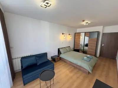 a bedroom with a bed and a blue couch at Nest by the Peaks Apartment in Bansko in Bansko