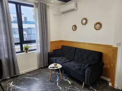 a black couch in a living room with a window at luxury Apartament TD one bedroom in Sofia