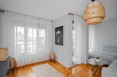 a white living room with a couch and windows at AeroLuxe Living 1BD Apartment by Flat Mаnager in Sofia
