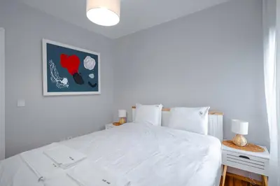 a bedroom with a white bed and a picture on the wall at AeroLuxe Living 1BD Apartment by Flat Mаnager in Sofia