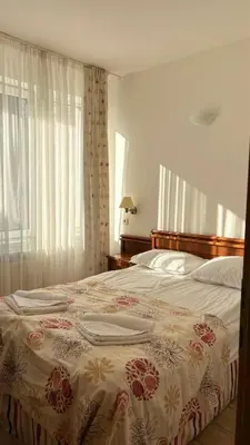 a bedroom with a large bed with a floral bedspread at Fantastic 1-bedroom apartment Stream Resort in Pamporovo