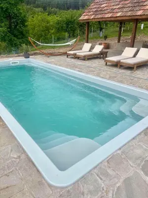 a large swimming pool with chairs and a gazebo at Вила Китна in Lozno