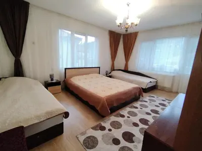 a bedroom with two beds and a chandelier at Къща за гости ЖАНИ in Zmeitsa