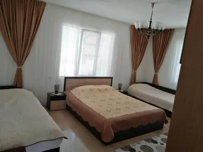 a bedroom with two beds and a chandelier at Къща за гости ЖАНИ in Zmeitsa