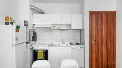 a kitchen with white appliances and a wooden door at Terra Vibes - Central 1BD with balcony by Flat Mаnager in Sofia
