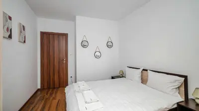 a bedroom with a white bed and a wooden door at Terra Vibes - Central 1BD with balcony by Flat Mаnager in Sofia
