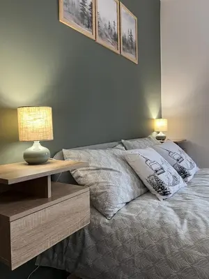 a bedroom with a bed and a table with a lamp at Bansko Gondola Apart in Bansko