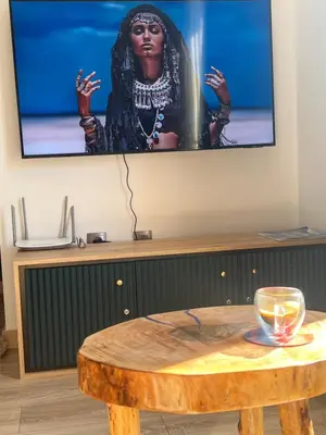 a tv screen with a table and a glass on it at Bansko Gondola Apart in Bansko