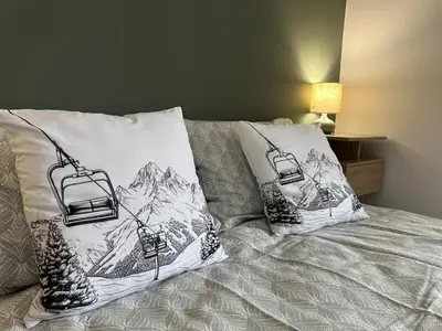 a bed with two pillows with a ski lift on it at Bansko Gondola Apart in Bansko