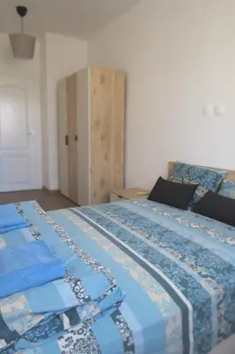 a bedroom with a bed with a blue and white quilt at Полименови in Sofia