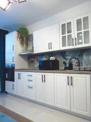 a kitchen with white cabinets and a sink at Полименови in Sofia