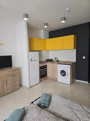 a kitchen with yellow cabinets and a washer and dryer at The Peak in Sofia