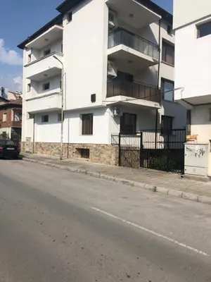 a white apartment building on the side of a street at При Бети in Sandanski