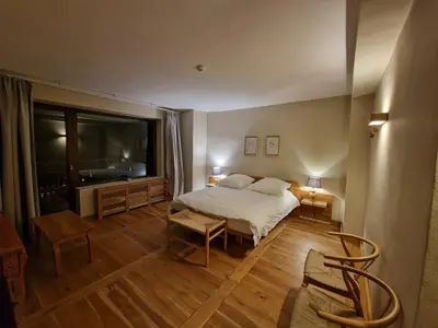 a bedroom with a bed and a large window at Хотел Гела in Gela