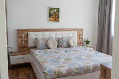 a bedroom with a bed with a wooden headboard at MirrArt House - Просторен луксозен апартамент - 3 спални - 2 бани - Топ център in Plovdiv