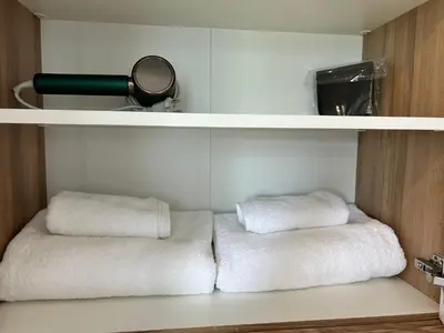 two white towels are sitting on a shelf at MirrArt House - Просторен луксозен апартамент - 3 спални - 2 бани - Топ център in Plovdiv