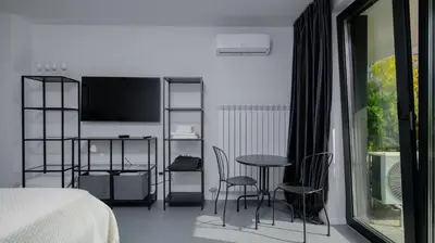 a bedroom with a bed and a table and chairs at Aviva City Stay by Flat Mаnager in Sofia