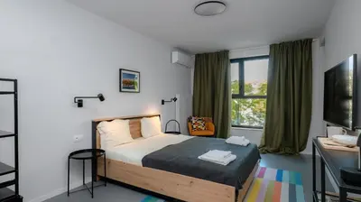 a bedroom with a bed and a desk and a window at Aviva City Stay by Flat Mаnager in Sofia