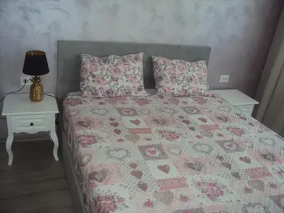 a bedroom with a bed and a table with a lamp at Apartment 13 in Sofia