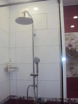 a shower in a bathroom next to a wall at Apartment 13 in Sofia
