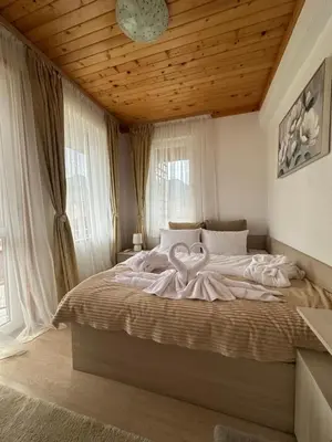 a bedroom with a large bed with a wooden ceiling at Къща за гости Падалото in Smolyan