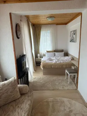 a large bedroom with two beds and a couch at Къща за гости Падалото in Smolyan